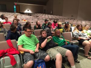 Students relax in the auditorium before the movie begins