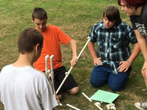 Students work with PVC pipes outdoors