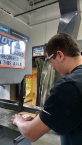 A male student uses a machine in the shop