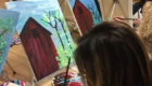School and community members paint a red barn scene at Paint N' Pizza Night