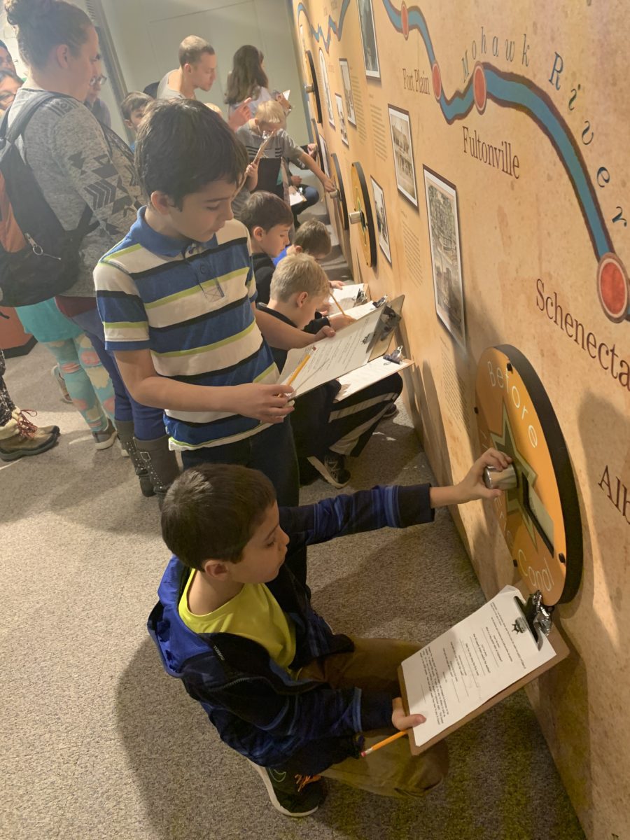 photo of students with clipboards exploring a museum display